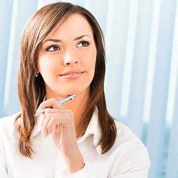 A woman with a pen looking up thoughtfully, considering a frequently asked question (FAQ).